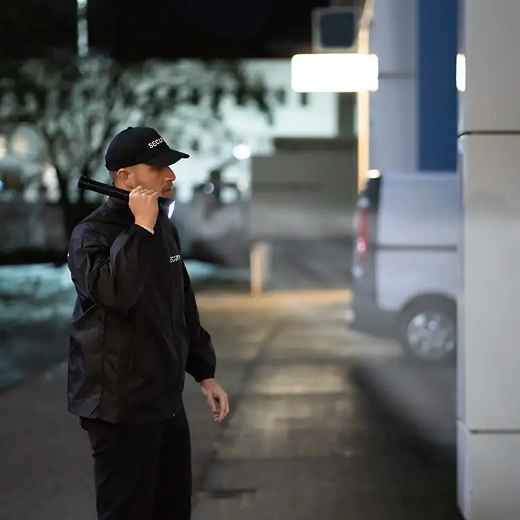 Ein Security-Mitarbeiter untersucht mit der Taschenlampe