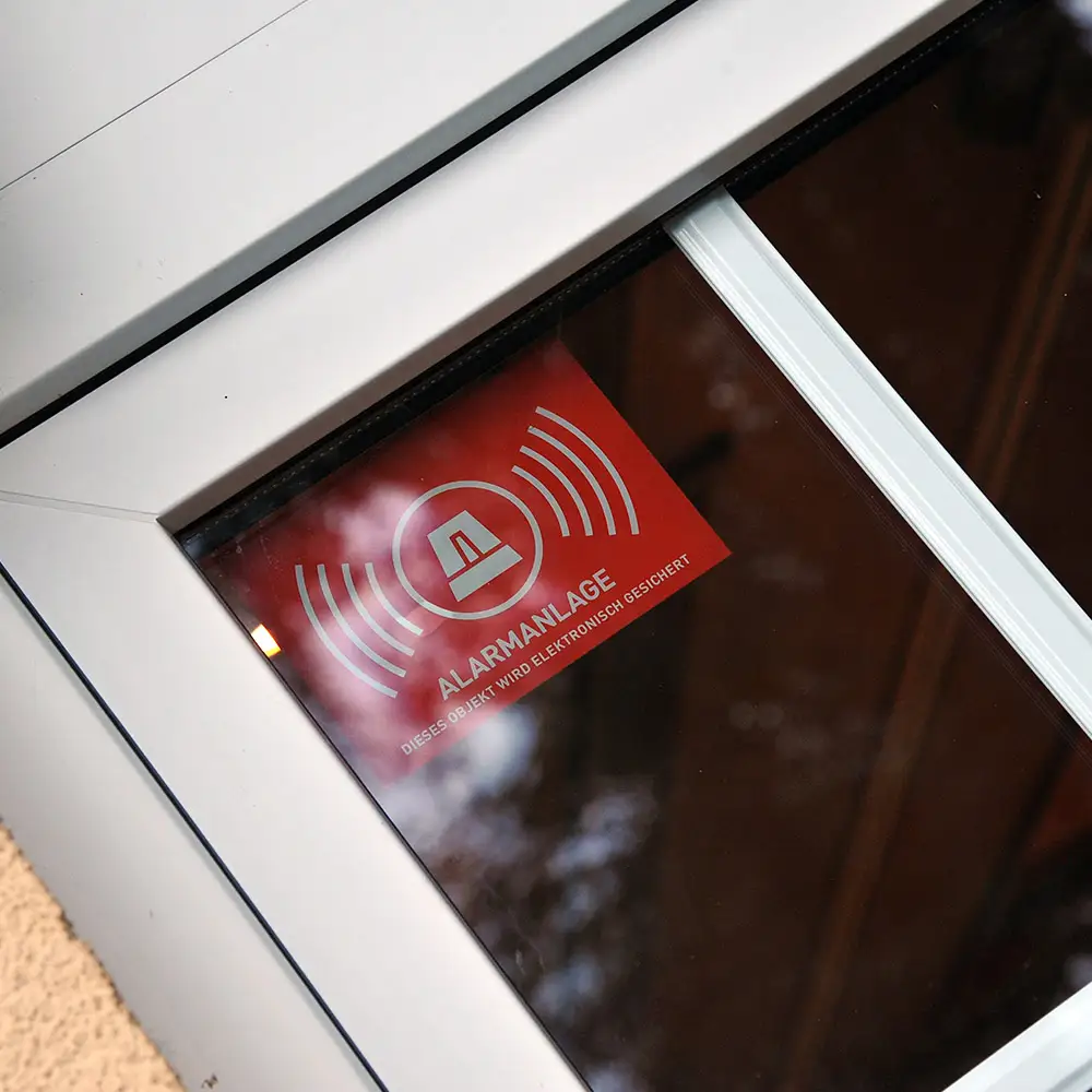 Warnschild "Alarmanlage" in einem Fenster